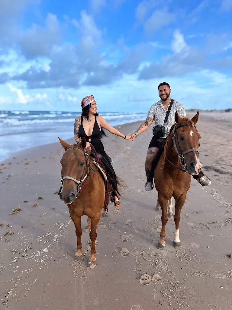 Couple horseback riding along the beach at sunset on South Padre Island